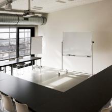 Lichte vergaderruimte met whiteboard en uitzicht over Gent